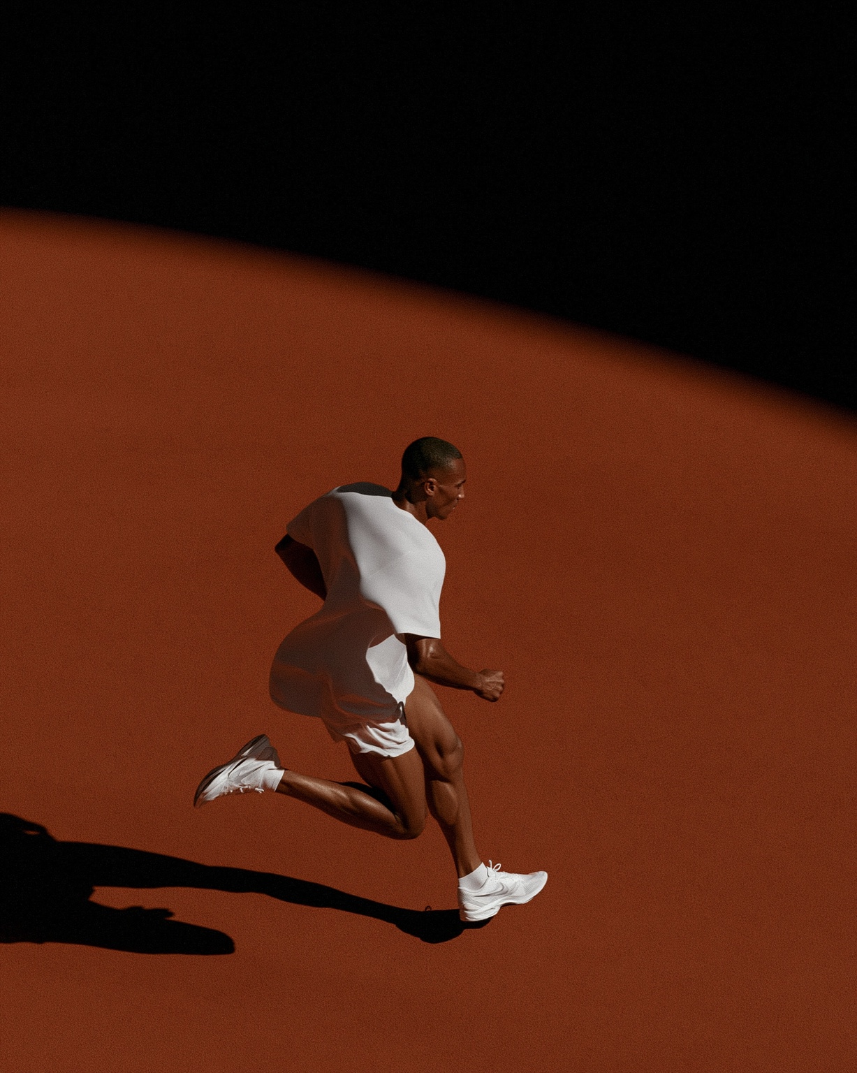 Male athlete running through warm red studio light